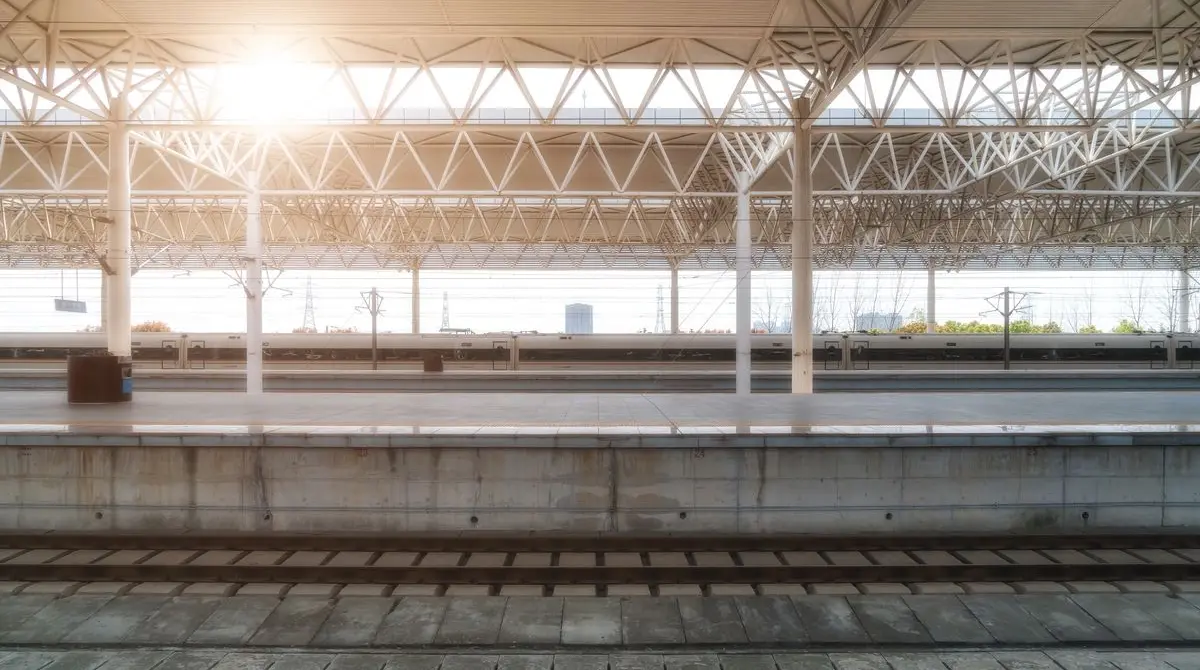 Tren i bardhë kinez i shpejtësisë së lartë duke pritur në platformën e një stacioni modern