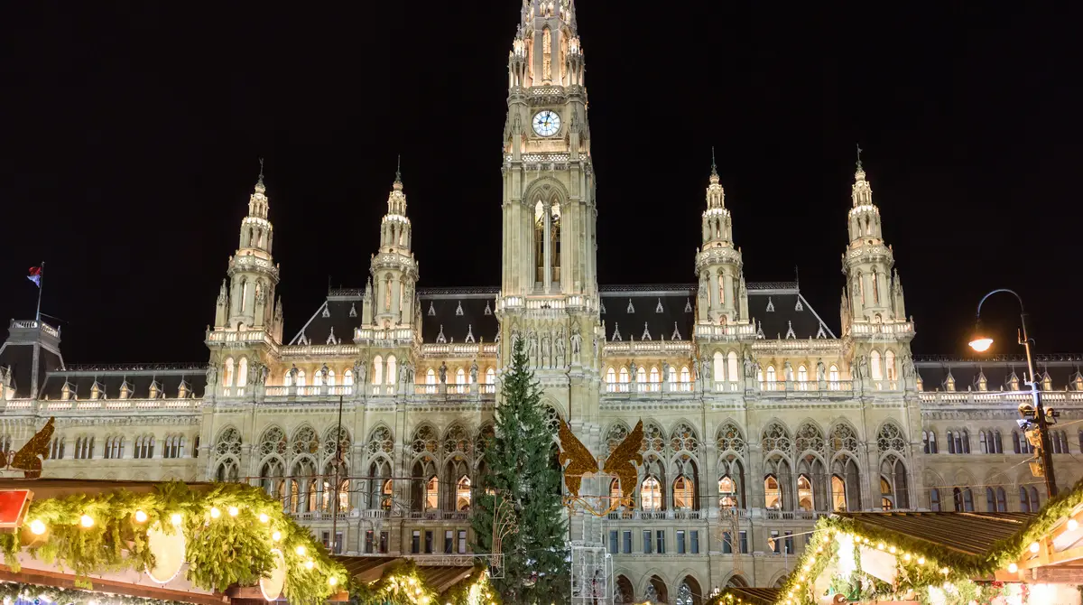 Tezga të ndriçuara festive të tregut të Krishtlindjeve para bashkisë së Vjenës natën