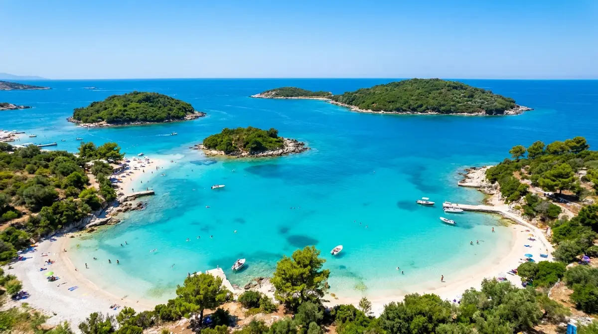 Pamje ajrore e plazhit të Ksamilit në Rivierën Shqiptare me ishujt e vegjël të gjelbër në ujë turkez gjatë verës