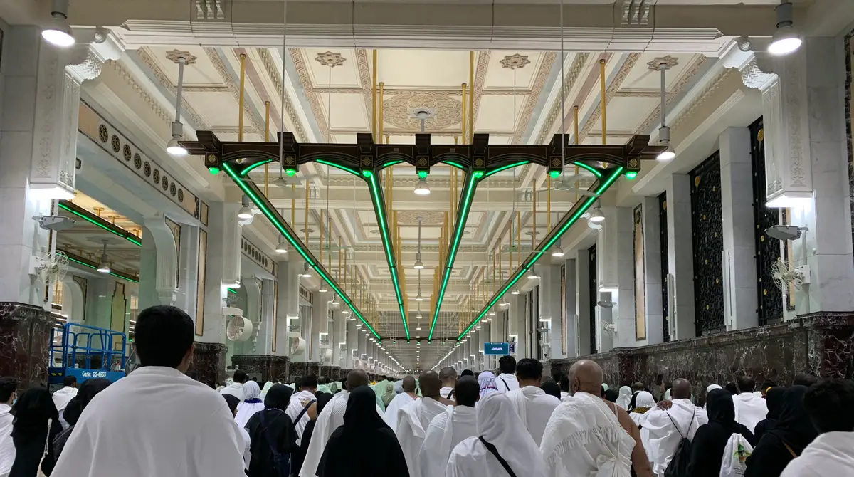 Pelegrinë në ihram duke ecur në korridorin e sajit mes Safasë dhe Mervas nën dritat e gjelbra brenda Xhamisë së Madhe në Mekë
