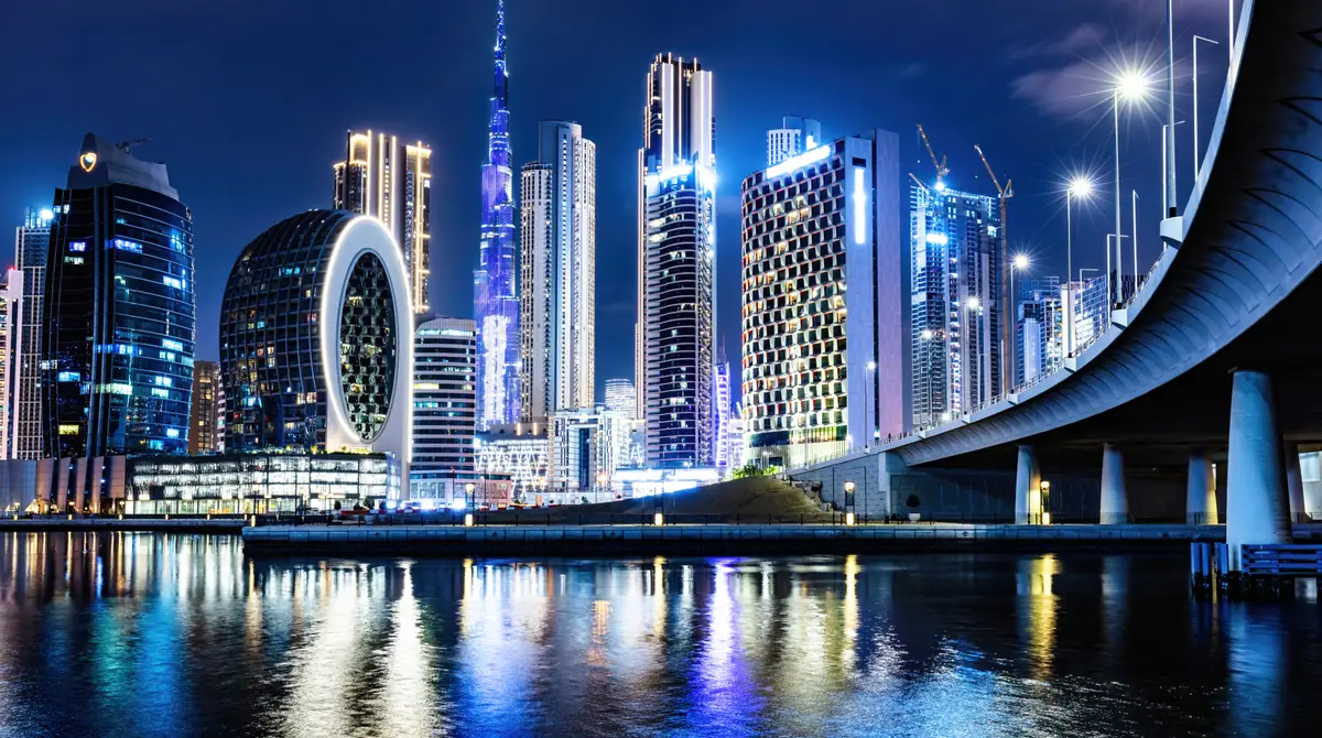 Silueta e Dubait natën me Burj Khalifa dhe kulla të ndriçuara që pasqyrohen në ujë