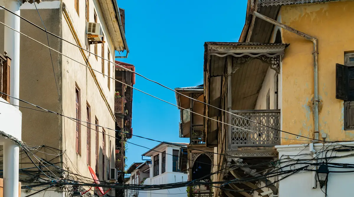 Narrow alley with carved wooden doors and old buildings in Stone Town, Zanzibar
